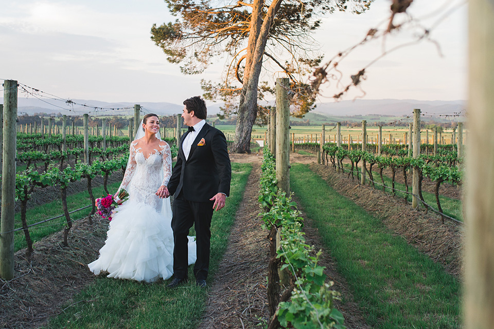 Clair and Angus walking through the vineyard after their wedding photography was completed.