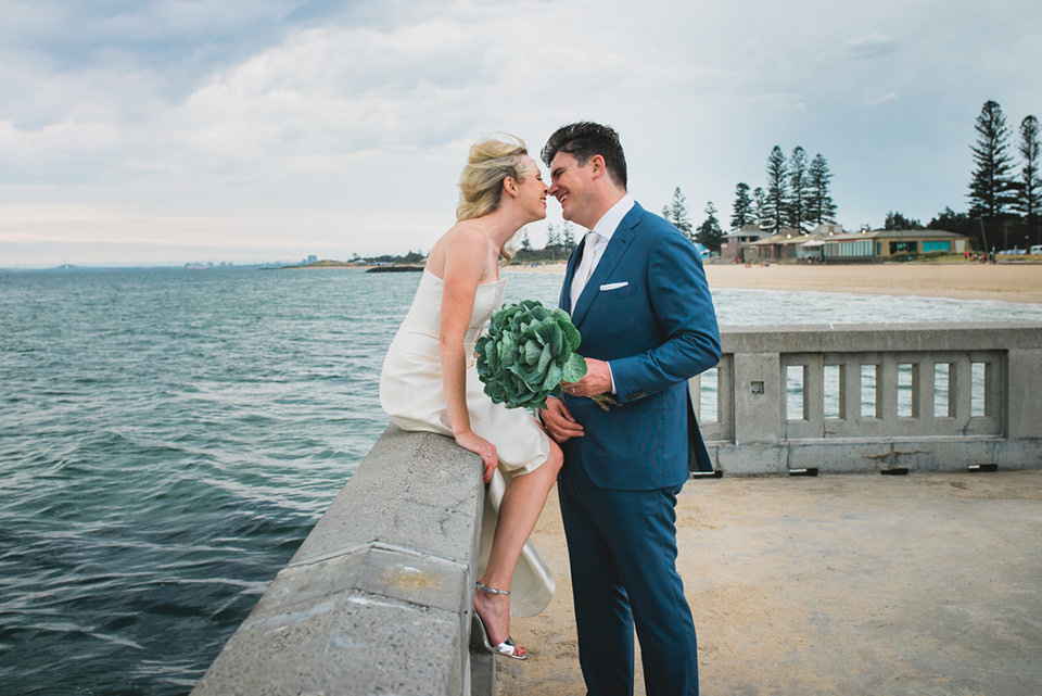 Anthea and James sitting at the pier in Elwood for their wedding photos.