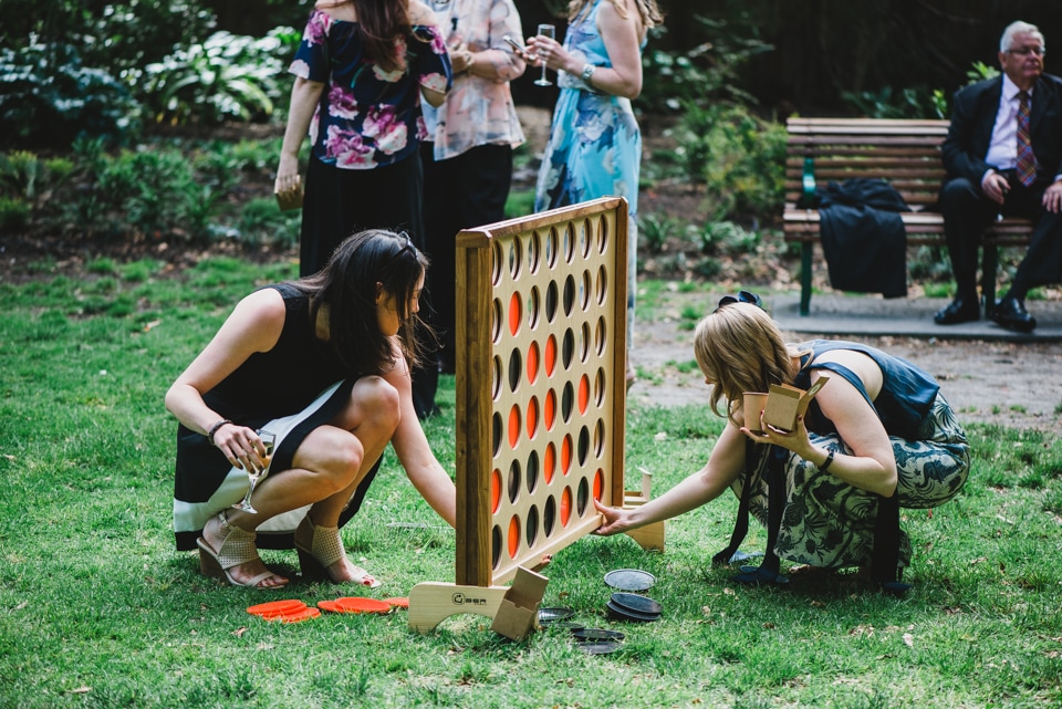 Wedding guests playing giant connect four and lawn games after the ceremony.