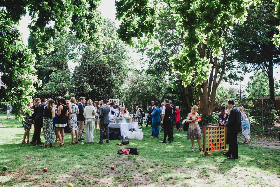 Wedding guests playing giant connect four and lawn games after the ceremony.
