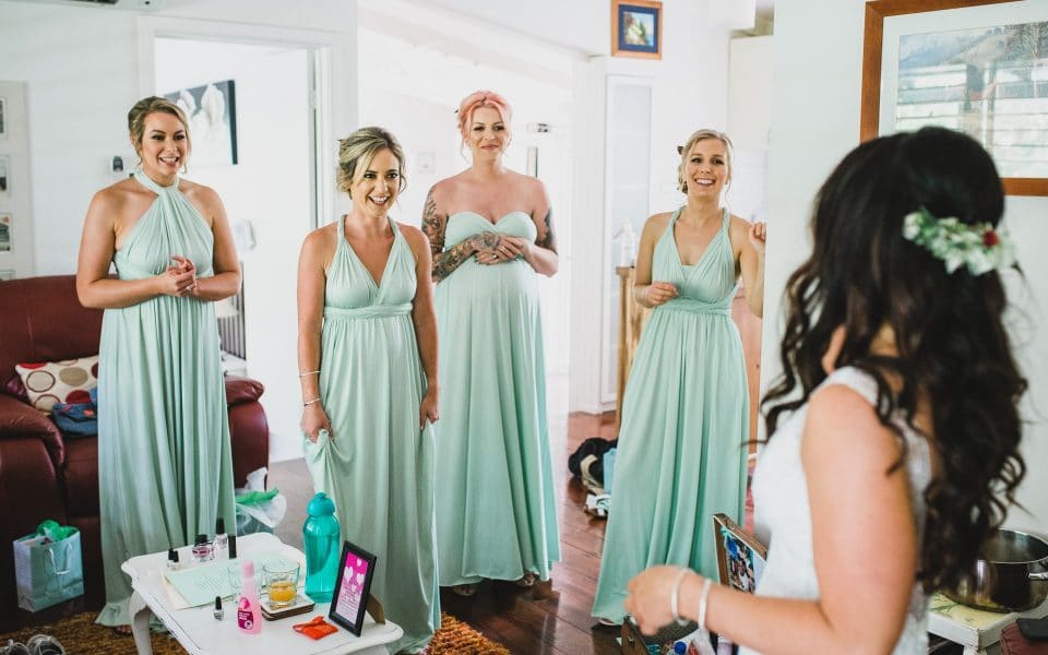 Bridesmaids seeing the bride for the first time with her wedding dress on.